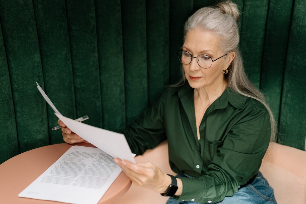 une dame âgée lit un document administratif